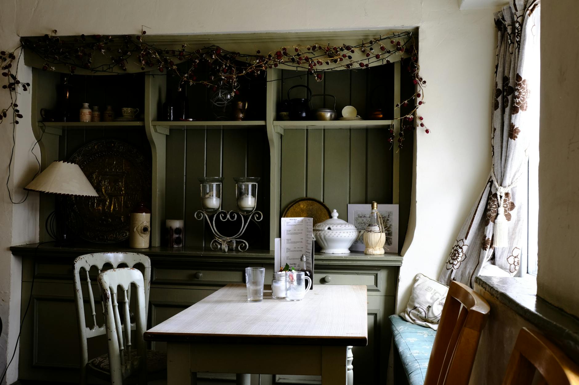 green display cabinet and white dining set in a kitchen